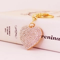 Eleganter goldener Herz-Schlüsselanhänger mit weißen Kristallen auf einem Buchhintergrund - Rosa Strass (Wie abgebildet)