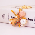 Llavero de estrella de mar y concha con perlas y diamantes de imitación en naranja - Naranja