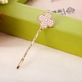 Detail einer vergoldeten Haarspange mit einem Kleeblatt-Design und kleinen Perlen - Vierblättriges Kleeblatt (Künstliche Perle Dekoration) / Perle