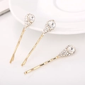 Dettaglio di tre fermagli per capelli dorati a fiore con brillanti strass di cristallo - Bianco