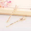 Close-up of golden bar hair clips with rectangular zircon crystals on a notebook - Gold Geometric Style