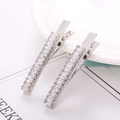 Macro shot of a pair of silver duckbill hair clips featuring luxury rectangular crystals - Silver Single Row Rectangular