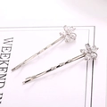 Detailed macro view of silver flower hair clips with white zircon crystals on a white paper - Silver Five-Petal Flower