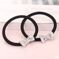 Dettaglio di elastici per capelli neri con ciondoli a fiocco in zircone e strass fini - Design Fiocco (Argento)