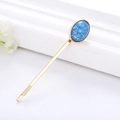 Minimalistische goldene Haarklammer mit ovalem Harzstein und blau-grünem Schimmer - Königsblau