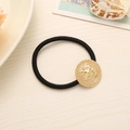 Elastic black hair tie featuring a vintage gold lion head medallion with ribbed edges - Round Lion Head