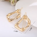 Detailed size view of two gold-plated bamboo-shaped alloy hair clips on a white tray - Letter D
