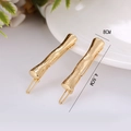 Dettaglio dei fermagli per capelli dorati texture bambù con misura di 4,6 cm di lunghezza - Lettera I