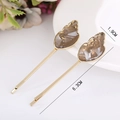 Detalle de horquillas de acetato con aleación dorada de 6,3 cm y adornos de resina ámbar - café