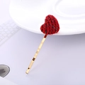 Dettaglio di un fermaglio per capelli a cuore rosso in maglia con glitter dorati su metallo - Cuore Rosso