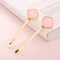 Pair of golden hairpins with pink glitter resin squares on pink aesthetic background - Body Glitter