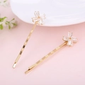 Dettaglio di fermagli per capelli dorati con lussuoso design floreale in cristallo - Stile Girandola D'oro / Oro