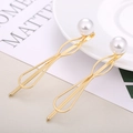 Dettaglio di fermagli per capelli dorati a onda con perle su un piatto bianco - Design a Navette con Goccia