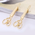 Elegante coppia di fermagli per capelli a forbice dorati con finitura metallica lucida - Stile Forbici Oro