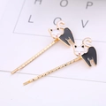 Detail view of cute cartoon cat hair clips with golden wavy pins and black oil-dripping finish - Black and White Cat