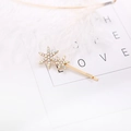 Detailed view of two gold snowflake hairpins with sparkling rhinestones and white feathers - Iridescent Star Snowflake