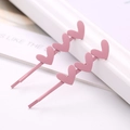 Detalle de horquillas de metal rosa mate con tres formas de corazón 3D en línea - Corazón Rosa