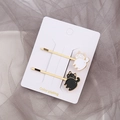 Detail von kreativen Katzen-Haarspangen in Gold mit schwarz-weißen Emaille-Motiven - Schwarz-weiße Katze