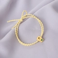 Detail of yellow elastic hair tie with cute fruit charm on purple fabric background - Pineapple