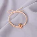 Close-up of orange elastic hair tie featuring a cute carrot charm and stylish bow knot - Carrot