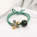 Détail du pendentif fleur de camélia et chouchou élastique vert orné d'une perle fine - Élastique Vert