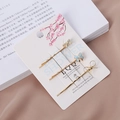Détail de trois barrettes dorées avec nœuds en émail bleu clair sur carte blanche - Ensemble / Bleu lac