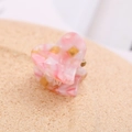 Macro shot of a pink marble acetate heart hair claw clip with golden metal spring - Pink