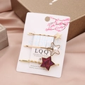 Detail view of 3-piece star hair clip set featuring gold finish, pearls and purple texture - Purple Star Set