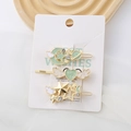 Détail de trois pinces à cheveux vert menthe avec étoiles et lune sur carte - Ensemble Bleu Nacré