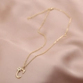 Détail du collier doré avec pendentif lettre C, petite fleur et zircon sur tissu en soie - Lettre C (Chaîne C)