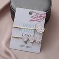 Elegante gouden haarspeldjesset met witte emaille bloemen op een cadeaukaart - Witte Smiley