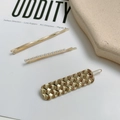 Close-up of three gold hair clips featuring a wavy bar, pearls, and a woven metal texture - Plaid Oval