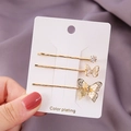 Set aus drei goldenen Haarklammern mit Schmetterlingsdesign und Acrylperlen-Details - Schmetterling Cremeweiß