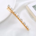 Detailed view of elegant gold hair clip with pearls and crystals on silk fabric - Gold Pearl Rhinestone