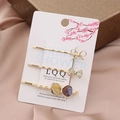 Close-up of golden hair clip set with rhinestone bow, marble resin, and faux pearls - Purple & Yellow