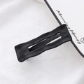 Detail of matte black wavy hair clip with frosted texture finish and metal structure - Rectangular Shape (Matte Black)