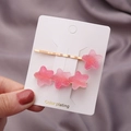 Lot de barrettes étoiles roses pailletées avec finition dorée sur fond de soie violette - Étoile Dégradé Rose Foncé