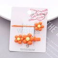 Détail de pinces à cheveux fleurs oranges texture mate sur une carte d'emballage cadeau - Orange Set