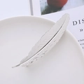 Dettaglio del fermaglio per capelli a piuma in metallo argento con texture su porcellana - Argento