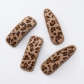 Detail of leopard print hair clips with velvet texture and golden rhinestone edges - Khaki Combo Style
