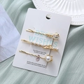 Détails de trois pinces à cheveux en métal doré avec perles sur une carte élégante - Style Poisson Crabe