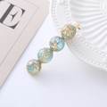 Detail of blue faux opal hair clip with gold foil flakes on a metallic duckbill base - Blue Gradient
