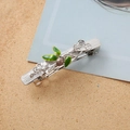 Detailed view of nature-inspired silver hair clip with green enamel leaves and beads - Silver Spring Clip