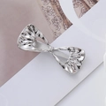 Detail view of silver metal wavy bow hair clip with textured metallic surface on card - Silver Pleated Bow Knot Style