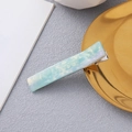 Detalle de la pinza cuadrada de acetato con textura de mármol azul verdoso iridiscente - Azul