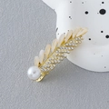 Close-up of golden leaf hair clip with cat-eye stones, rhinestones and a white pearl - Cat Eye Rhinestone Wheat Ear