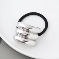 Detailaufnahme eines metallischen silbernen Haargummis mit hochelastischem schwarzem Seil - Silber Dreifach Halbrund