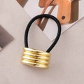 Dettaglio del charm a tubo in metallo dorato su elastico per capelli nero da donna - Oro Quattro Piccoli Semicerchi