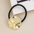 Close-up of black elastic hair tie with a textured gold metallic wave disk charm - Gold Round