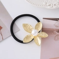 Detail of golden flower hair tie with hammered texture and a white pearl on white background - Gold Flower Style 4